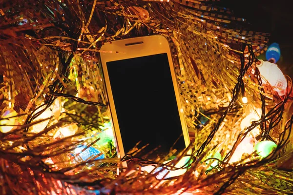 Noel ışıkları o ve smartphone — Stok fotoğraf