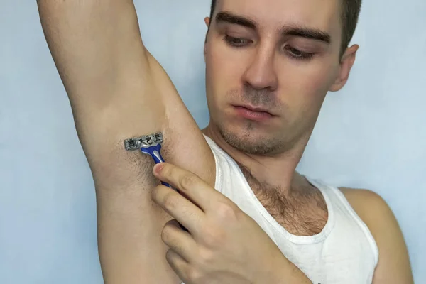 Man with razor while shaving armpits — Stock Photo, Image