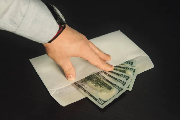 アメリカドルの白い封筒にその指を持っている男性の手 — ストック写真