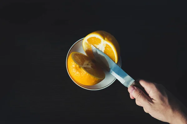Coupe de personne pour faire du jus à partir d'oranges fraîches sur une table en bois — Photo