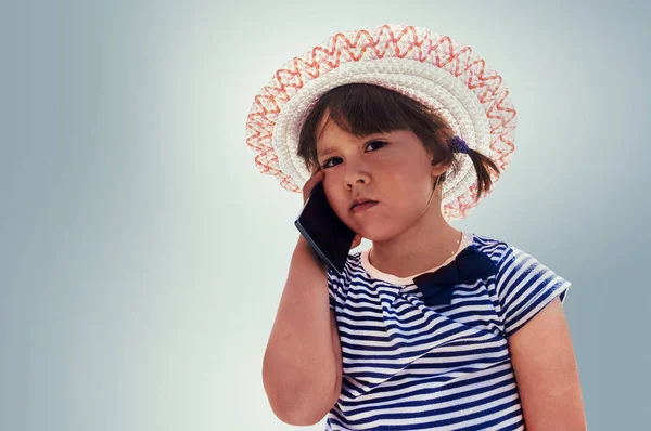 Lilla vackra flicka talar på din smartphone — Stockfoto