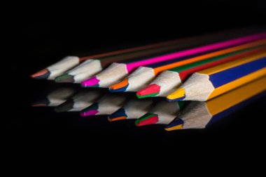 Bir yansıtıcı cam ayna yüzey üzerinde renkli kalemler