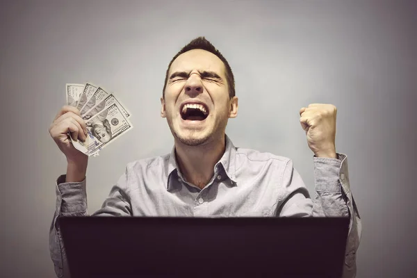 Hombre es feliz delante de la computadora para sostener 500 dólares — Foto de Stock