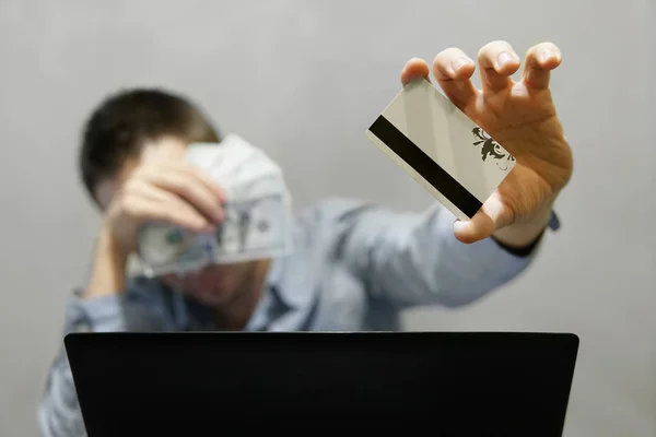 Mann mit Kreditkarte in der einen Hand und Geld in Dollar in der anderen — Stockfoto