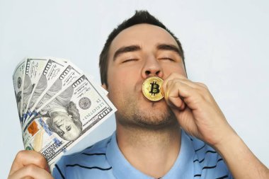 Adam altın sikkeyi öpüyor. Bitcoin kazanmaktan zevk alıyor.