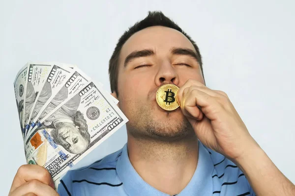 Adam altın sikkeyi öpüyor. Bitcoin kazanmaktan zevk alıyor.