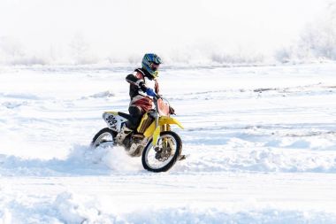 bir Motosiklet Racer sırayla tekerlekli bir sprey kar sürmek.