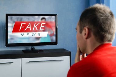 The guy watching the fake news on TV. Corrupt journalism. clipart
