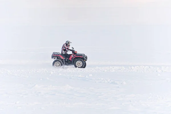 Muž jízdy čtyřkolku v poli zimní — Stock fotografie