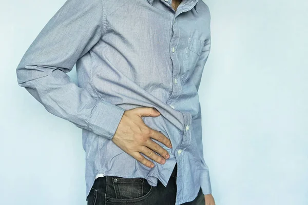 Człowiek z bólu żołądka na niebieskim tle — Zdjęcie stockowe