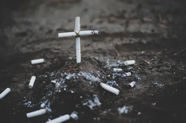 Un cimetière avec une tombe faite de cigarettes — Photo