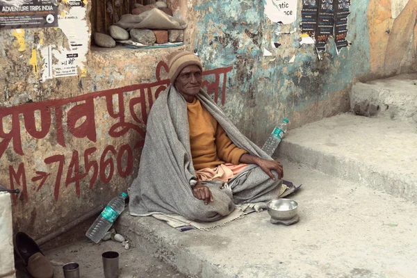 An old Indian beggar waits for alms on a street — Stock Photo, Image