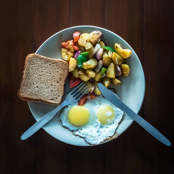 Жареные яйца с овощным рагу и хрустящие тосты в тарелке . — стоковое фото