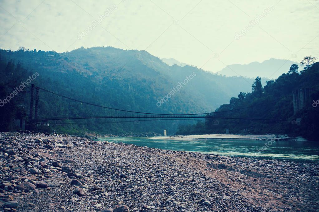 A beautiful landscape in the mountains with a bridge over the Ganges River