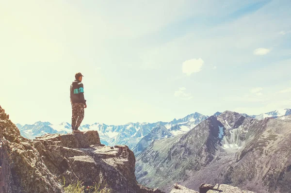 Un hombre está en la cima de una montaña — Foto de Stock