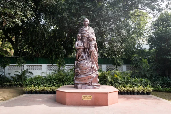 La estatua de Mahatma Gandhi con niños en bronce de pie en el patio —  Fotos de Stock