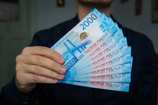 Новые российские банкноты номиналом 2000 рублей в мужских руках — стоковое фото