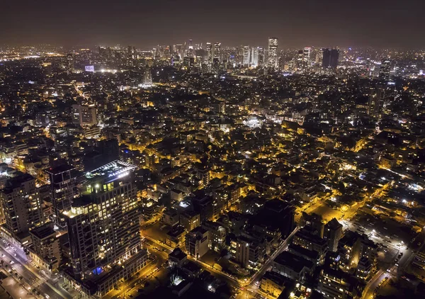 Tel Aviv escena nocturna, vista panorámica de los distritos centrales de Tel-Aviv en la noche oscura. Megalópolis vida después de la puesta del sol. Vida nocturna en Isreal segunda gran ciudad. Edificios iluminados y calles de la ciudad — Foto de Stock