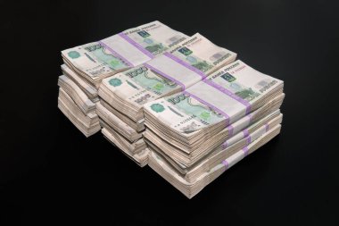 Milyonlarca ruble Rus rublesi. Büyük bir tomar para. Siyah arka planda Rus banknotları.