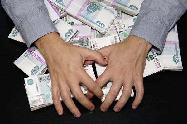 Las manos de los hombres buscan un fajo de dinero. Un millón de rublos en la mesa negra. El concepto de riqueza, éxito, codicia y corrupción, lujuria por el dinero —  Fotos de Stock