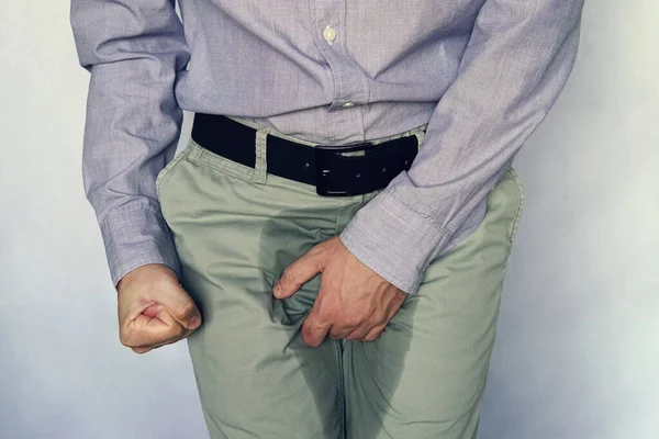 Men are scratching penis against blue gray background. People itching crotch. Human body problem or healthcare and medicine concept. incontinence and wet pants — Stock Image Men are scratching penis against blue gray background. People itching crotch. Human body problem or healthcare and medicine concept. incontinence and wet pants Stock Image