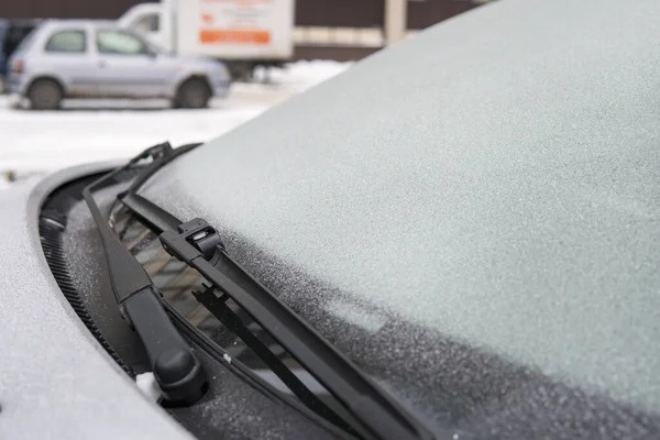 차가운 자동차 위에는 얼음으로 된 눈송이가 있습니다. 자동차의 바람막이 와이퍼. 자동차 관리인은 낮은 온도에서 차 유리에 얼어붙었습니다. 겨울에는 차에 문제가 있습니다. 가까이 서. — 스톡 사진