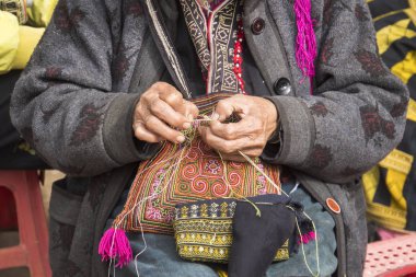 Sa Pa kırmızı dzao etnik azınlık kadın dikiş, Lao Cai eyaleti, Vietnam. Yaşlı bir kadın sokakta dikiş diker. Turistler için bir hatıra olarak güzel nakış olun