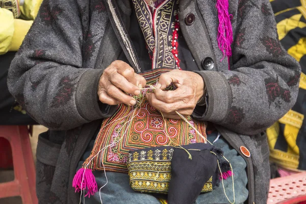 Sa Pa kırmızı dzao etnik azınlık kadın dikiş, Lao Cai eyaleti, Vietnam. Yaşlı bir kadın sokakta dikiş diker. Turistler için bir hatıra olarak güzel nakış olun