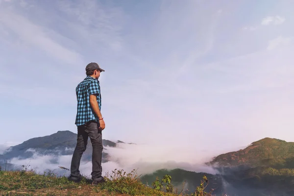 Hombre en las montañas mirando a la distancia. Viajero joven de pie y mirando a la naturaleza en Sapa Vietnam en temporada de lluvias — Foto de Stock