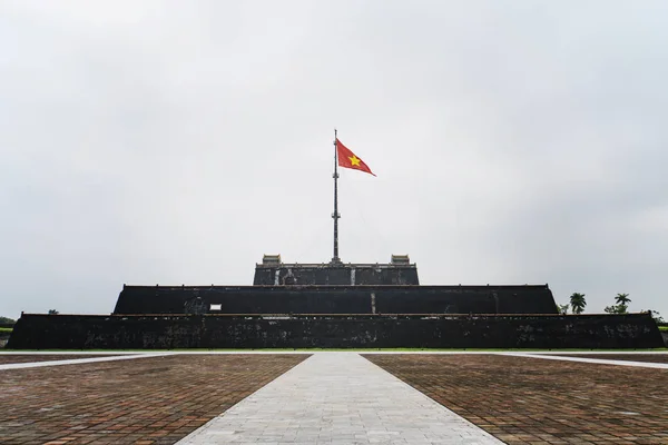 Bandeira do Vietnã sobre uma torre da Cidadela no fundo do céu azul. Dentro da Cidadela está a Cidade Proibida. Hue, Vietname — Fotografia de Stock