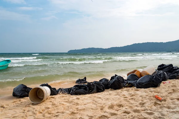 Garbage on beach, environmental pollution. black garbage bags on sand on an island in Asia. Garbage collection, cleaning of the nature, garbage collection on the beach.