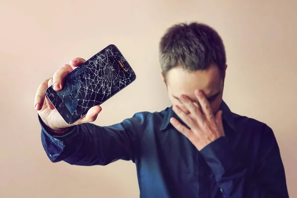 Barbudo hombre molesto sostiene una tableta o teléfono inteligente fuera de uso — Foto de Stock