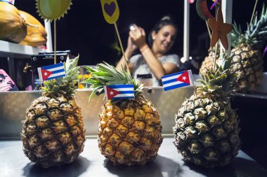 Genç Latin Amerikalı kız geceleri sokakta Pina colada kokteyli hazırlıyor..