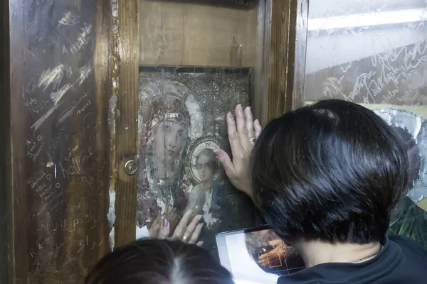 Woman touches an icon of the blessed virgin Mary in Church. — Stock Photo, Image