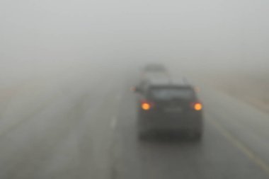 Poor visibility on the road. Fog early in the morning on the highway. slow-moving cars in heavy smoke from forest fires. Dangerous traffic. Bad weather. Slippery asphalt. driver's eyesight is poor