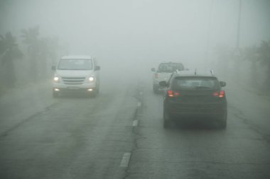 Yoğun sis ve yolda kötü görüş. Tehlikeli sürüş durumları. Karayolu trafik görüntüleyin. Puslu sabah. Düşük görünürlük. Yolda sigara. yalak sis sürüş araba. yolda acil tehlike.