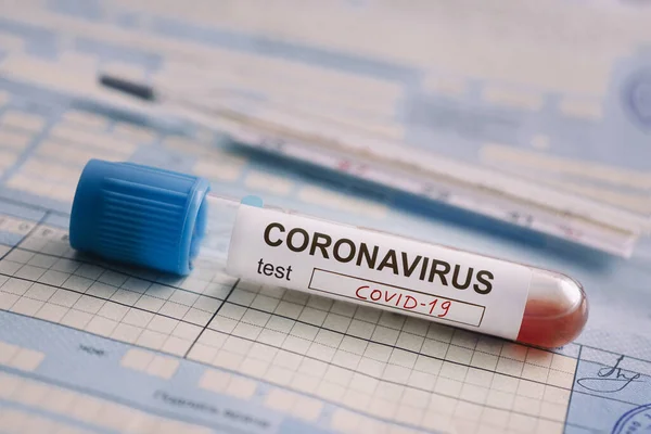 Tube à essai avec le test sanguin est sur la table à côté des documents. Test positif pour le coronavirus covid-19. concept de lutte contre une maladie chinoise dangereuse . — Photo