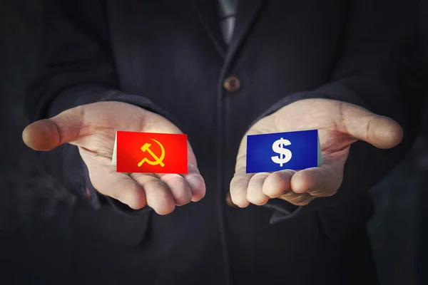 choice of political system is communism or capitalism. sign hammer and sickle or a dollar in the hands. concept of political party elections or misled by the worldwide government.