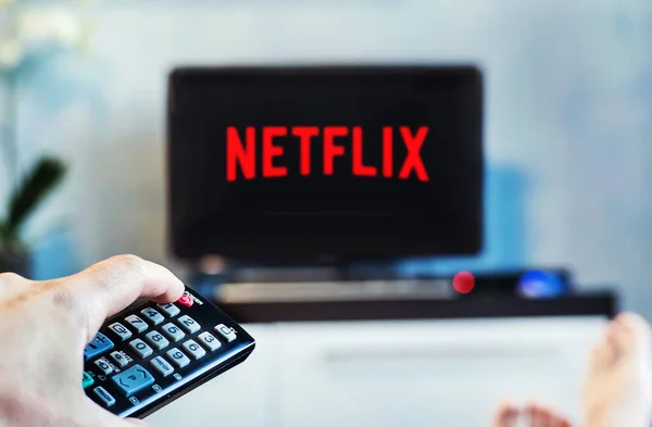 Молодой человек смотрит Netflix по телевизору и дома. Телевизор на переднем плане, размытый фон на телевизоре. — стоковое фото