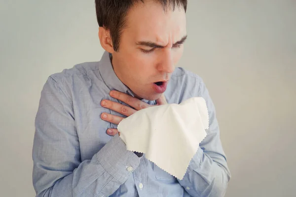 a young businessman coughing into a rag napkin to spread viral germs. Man Coughing. cough into a rag