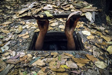 concept of self-isolation from viruses and diseases. hopper from obbedience. man hides in a hole. Vietnam's cu Chi tunnels for camouflage during us -Vietnam war. bomb shelter from the bombing. Hide in clipart
