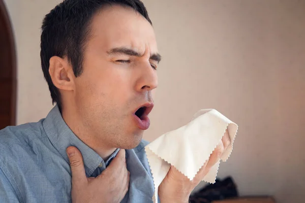 Man Coughing. a young businessman coughing into a rag napkin to spread viral germs. cough into a rag