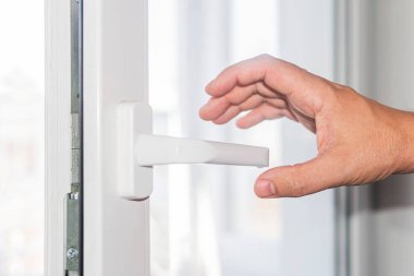 Adam elini kapı koluna koyup kapıyı açmaya çalışıyor. Deri hastalığı ya da virüs kapma riski.