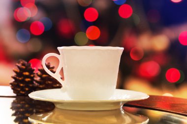 fincan sıcak çay veya kahve ve backg ışıkları ile Noel ağacı