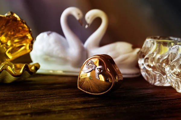 Nahaufnahme goldene Geschenkschachtel mit Herz auf altem Holztisch — Stockfoto