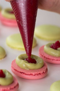 Kadının elinde bir acıbadem kurabiyesi krema sıkma.