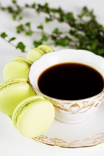 Colorful macaroons and a cup of coffee on wooden table. — Stock Photo, Image