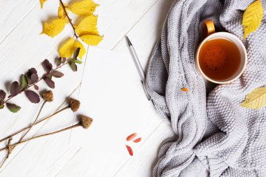 Bir fincan çay ile ahşap zemin üzerinde sonbahar flatlay 