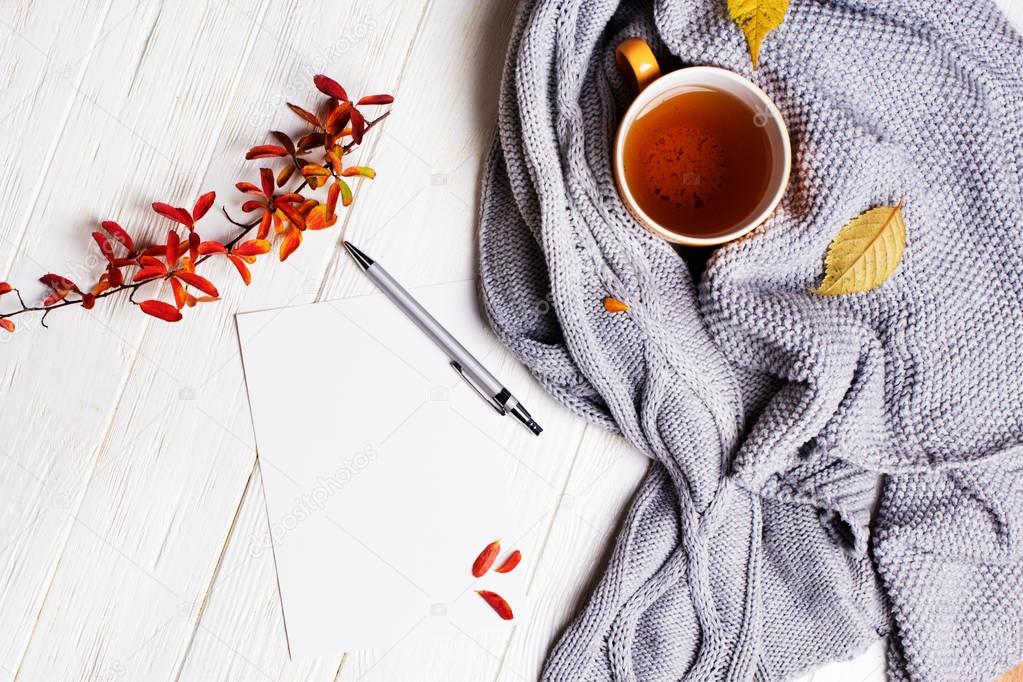 Autumn flatlay on wooden backdrop with a cup of tea and  fallen 