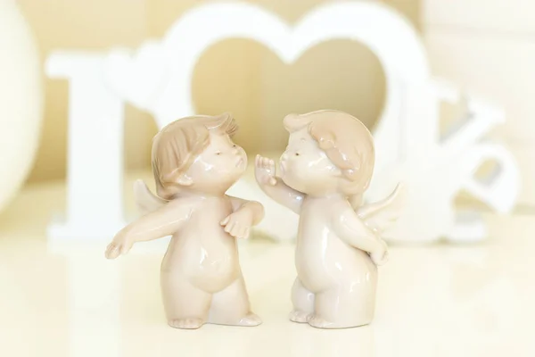 Statuettes of small angels. Two angels with white wooden letters — Stock Photo, Image